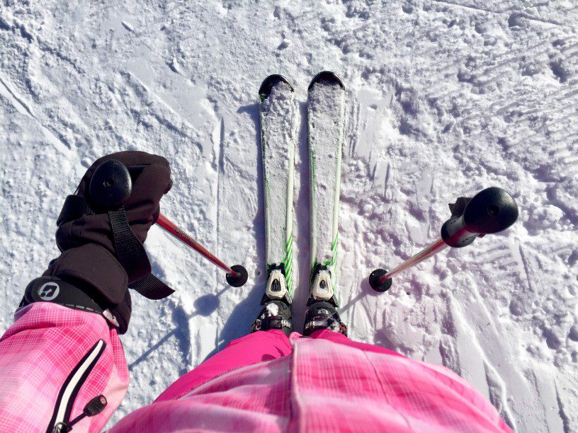 woman wearing pink ski costume looking down at her skis t20 WQzmOK